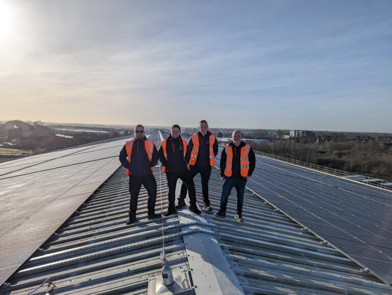 Team from Harvest Green Developments on a commercial roof alongside a solar array installation.