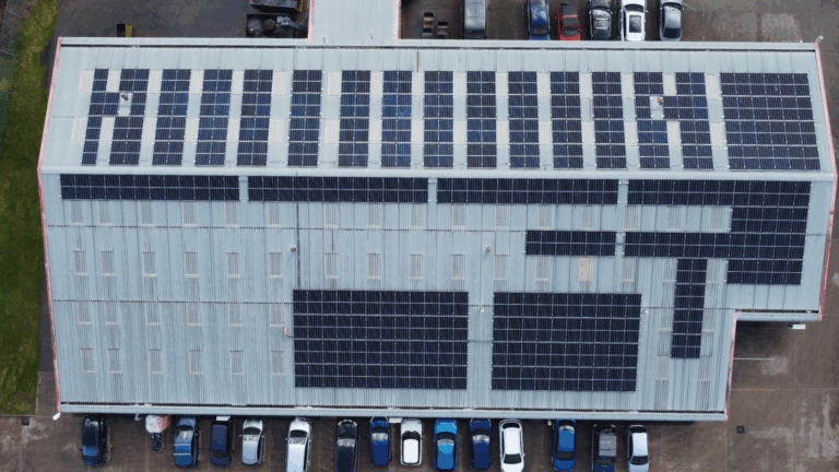 a drone shot of solar panels installed on a commercial roof to showcase solar panel utility bills reductions